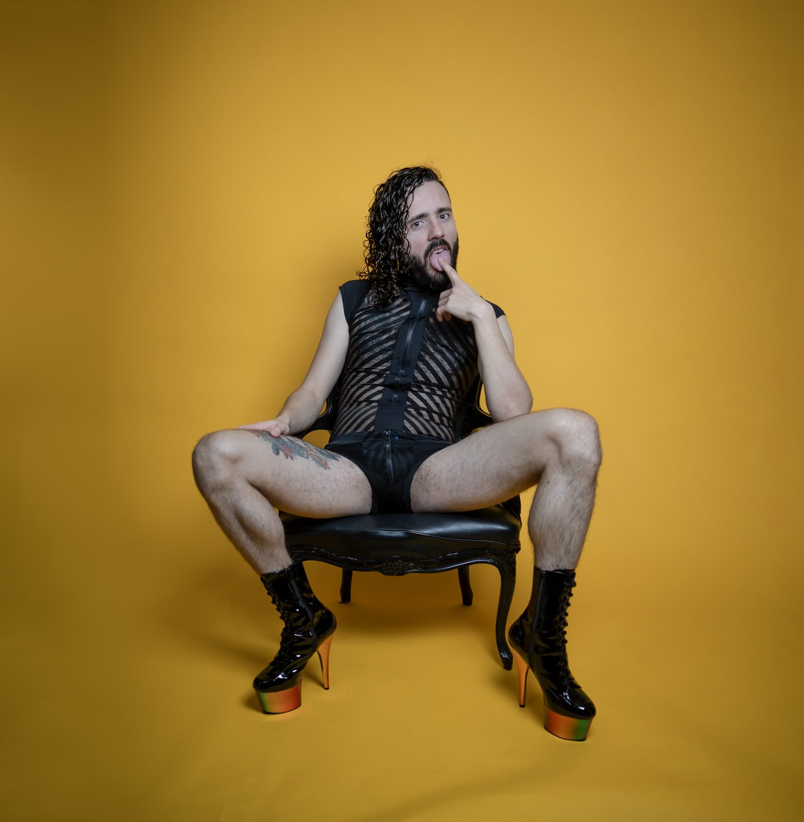 Princess Boy seated against a yellow background, tongue out
